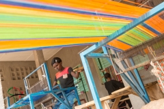 Woman weaving thread on a loom
