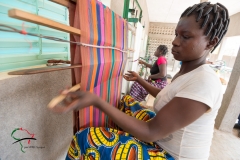 Woman weaving thread on a loom