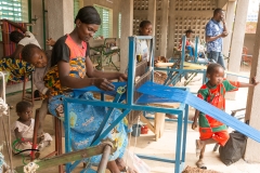 Woman weaving thread on a loom