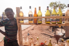 Boy standing next to bottles of motor oil