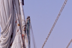 Man climbing the mast of a felucca In Aswan, Egypt