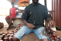Drum maker adding string to a drum in Accra, Ghana