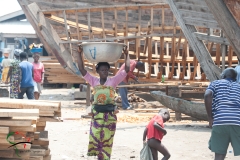 Woman carrying a bucket on her head in Elmina, Ghana