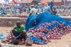 Man mending a fishing net in Elmina, Ghana