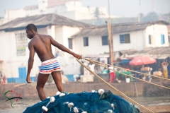 Man pulling a rope in Elmina, Ghana