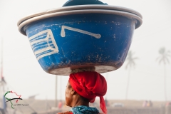 Woman with a bucket on her head in Elmina, Ghana
