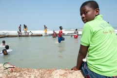 People in the water at a beach in Winneba, Ghana
