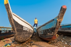 Man standing on pirogues in Accra, Ghana