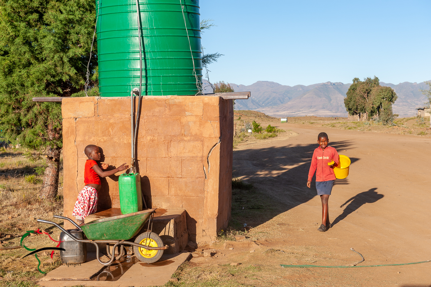 Children filling up containers at water tank