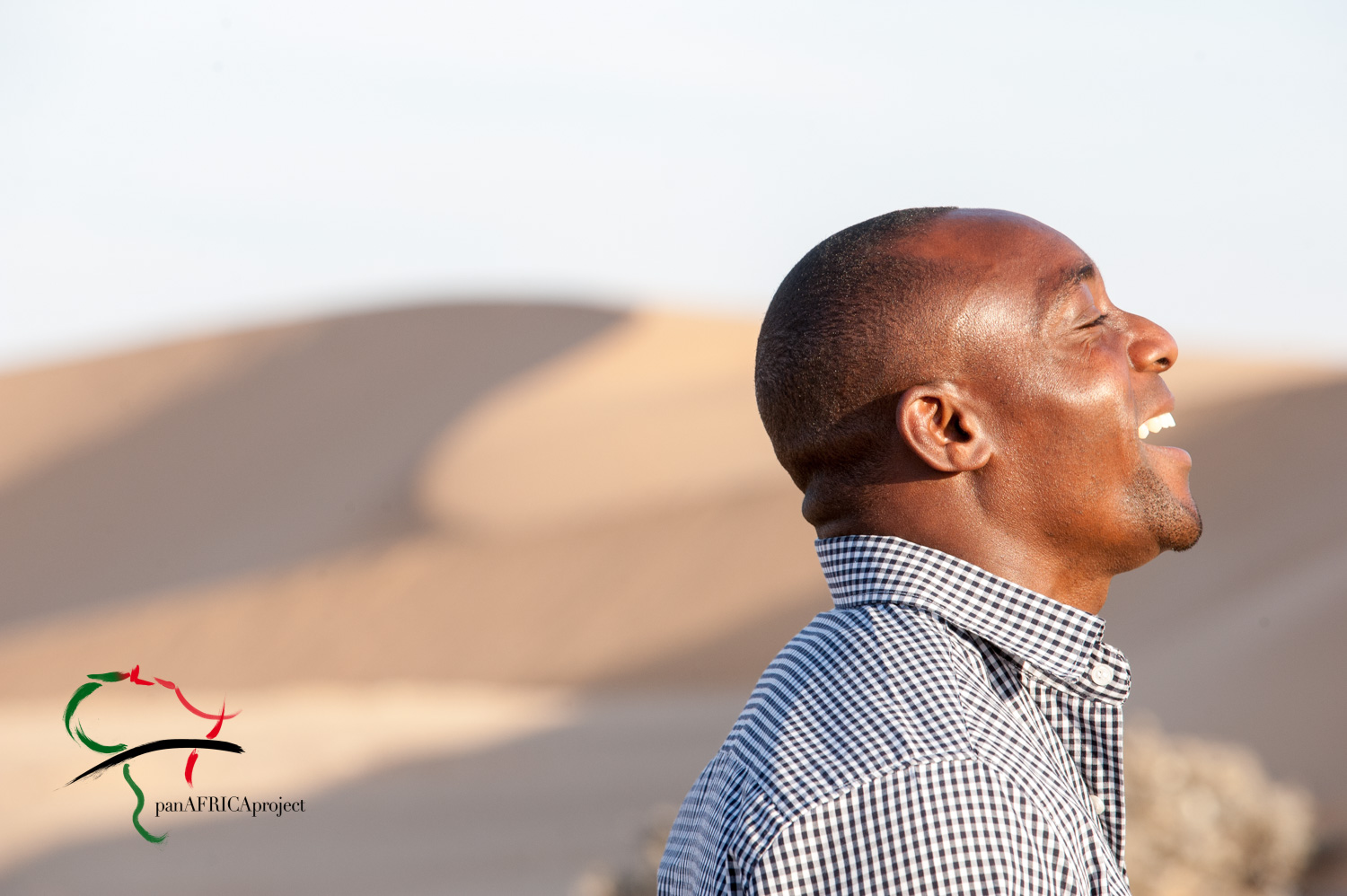 Profile of man in front of sand dunes.