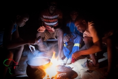 Men from the Herero Tribe cooking with an open flame.