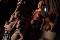 Mother and son from the Himba Tribe inside their hut.