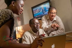 Employees at The Namibian woking on a computer.