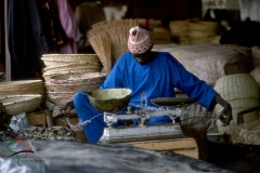 Vendor using scales at a marketplace in Kaolack, Senegal