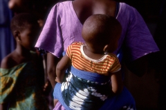 Woman carrying child on her back in Dakar, Senegal