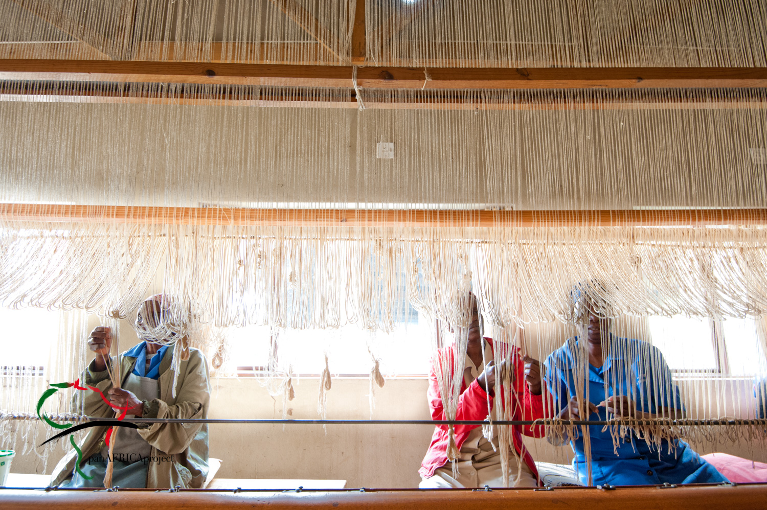 Women hand weaving a rug