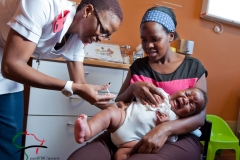 Nurse administering polio vaccine to infant patient