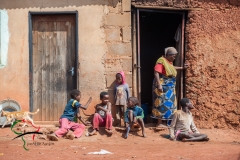 Family sitting in front of house
