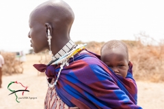 A child being carried on the back of his mother