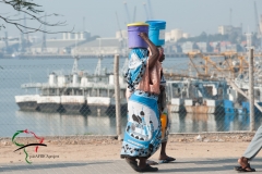 Women walking while holding buckets on their heads