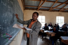 A professor writing on a black board