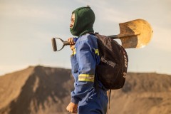 A copper mine worker holding a shovel