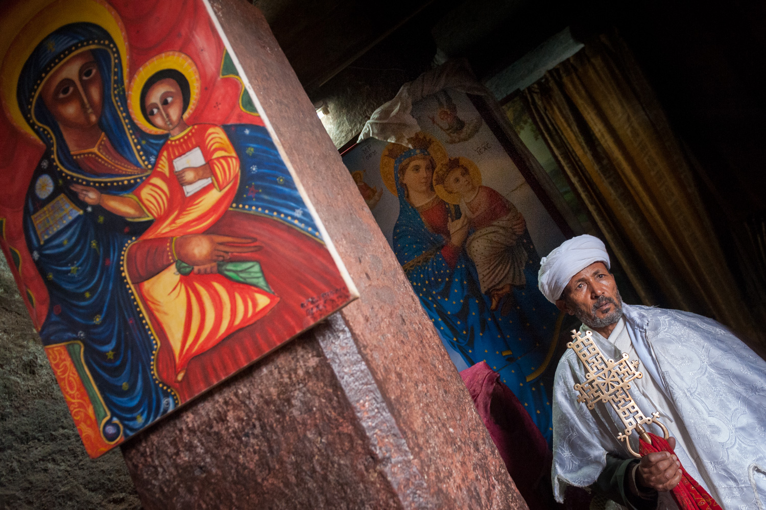 Priest and icons in monolithic church - Lalibela, Ethiopia