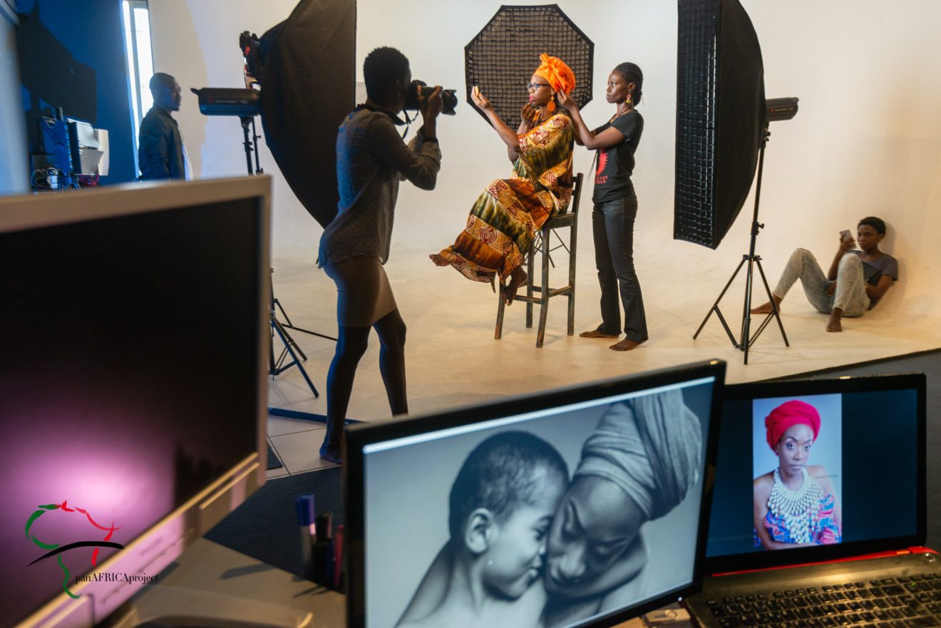 A photographer taking photos of a woman in his studio