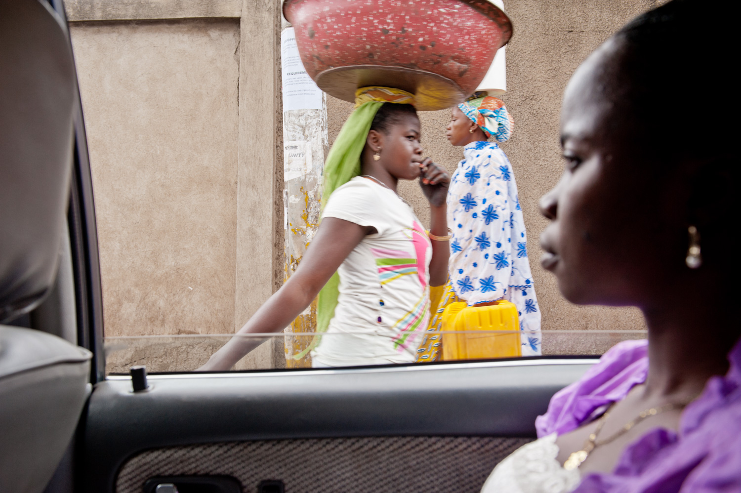 Woman sitting in a car with women in background